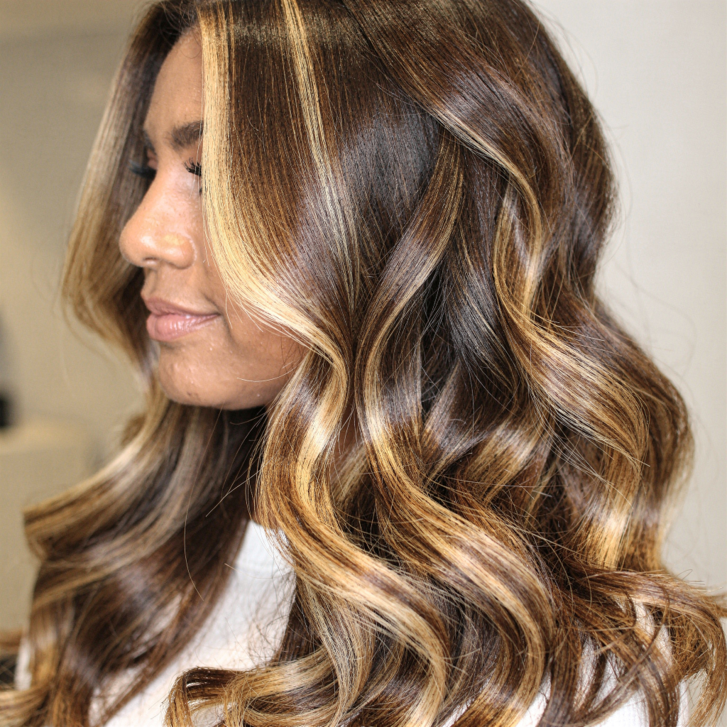 Caramel blonde balayage curls on dark hair