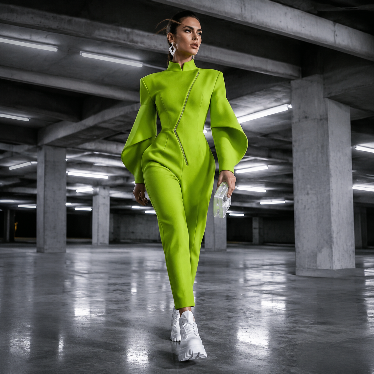 Person in neon green jumpsuit and white sneakers walking through a concrete parking garage, holding a clear clutch