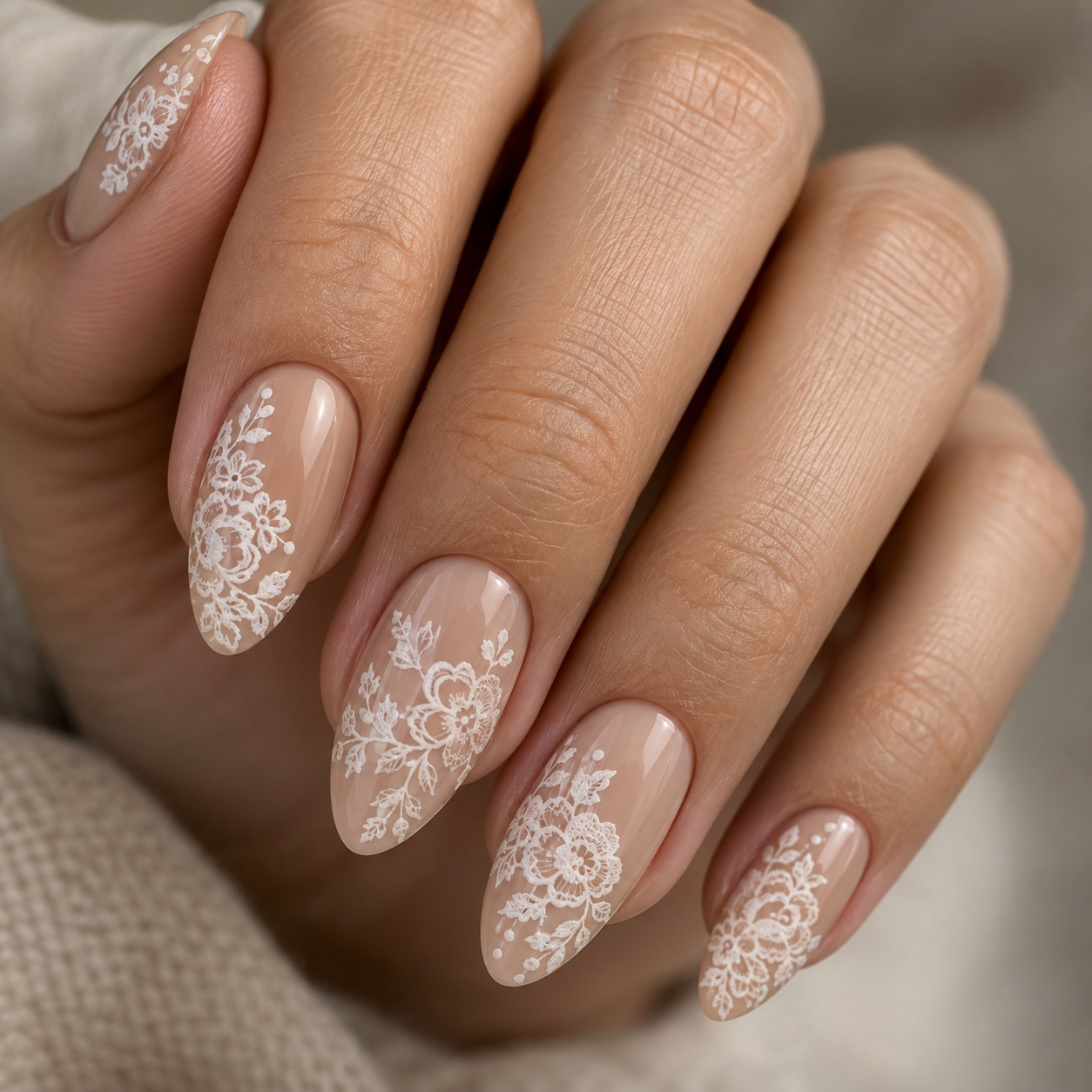 White floral lace nail art over a glossy nude base.