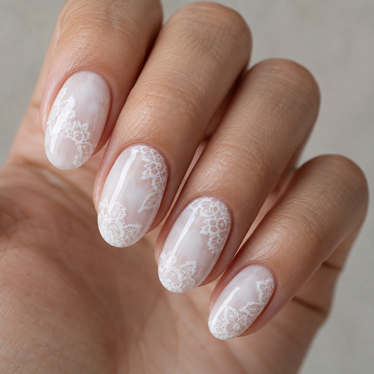 Milky white nails with delicate brighter white lace patterns.