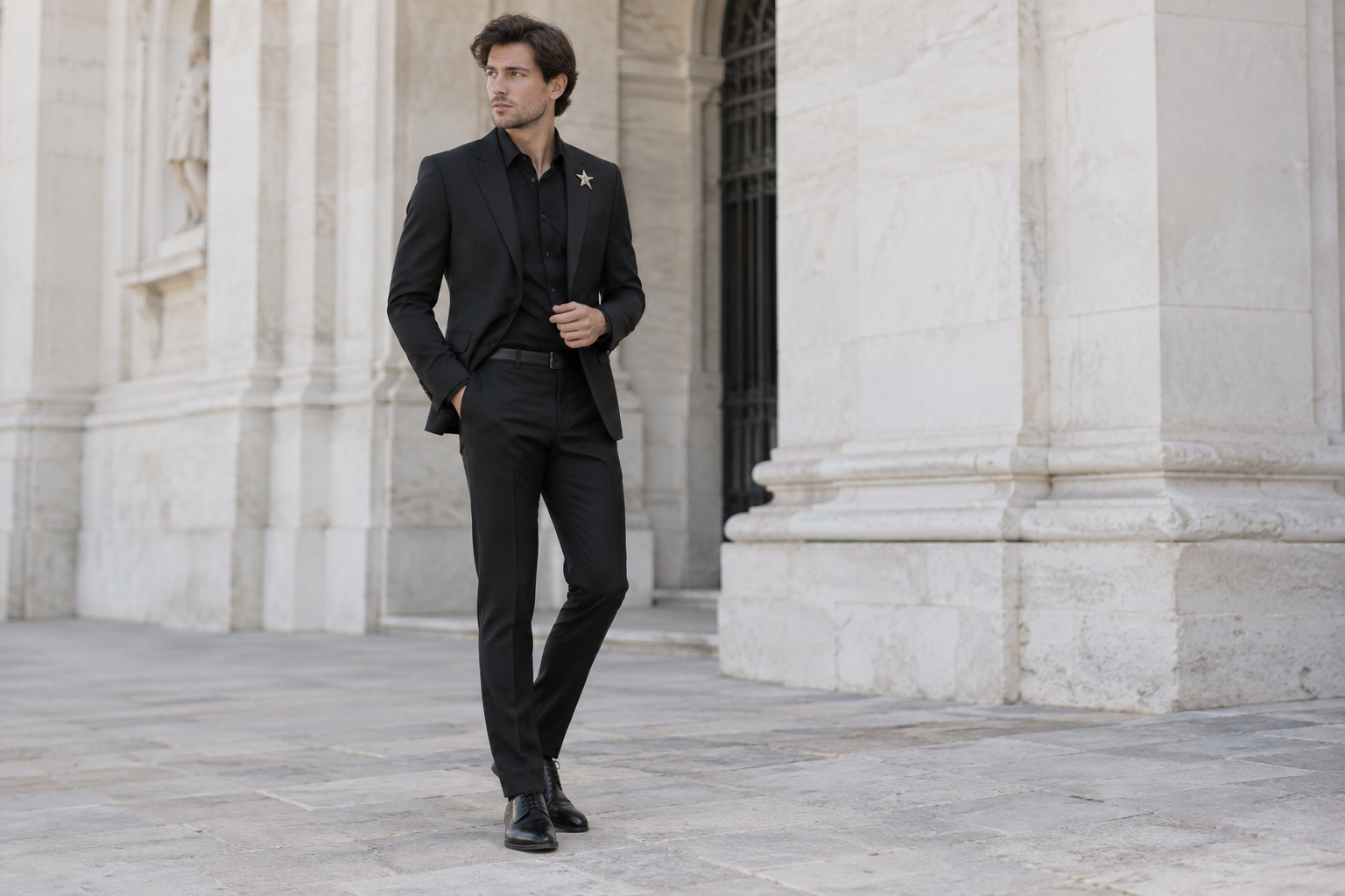 Black suit and black shirt styled with a silver star brooch.