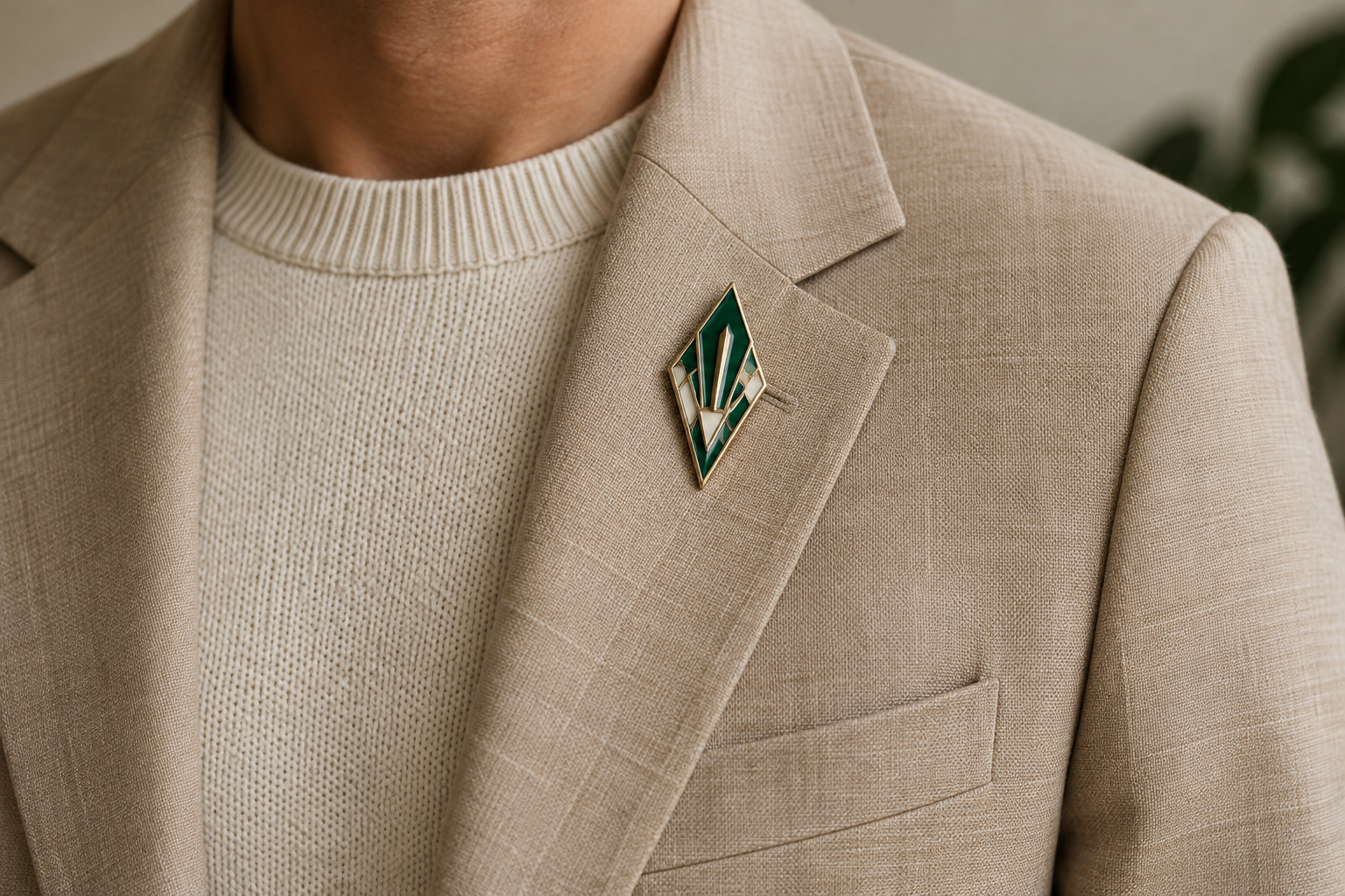 Green and cream enamel brooch on a sand blazer with cream knitwear.