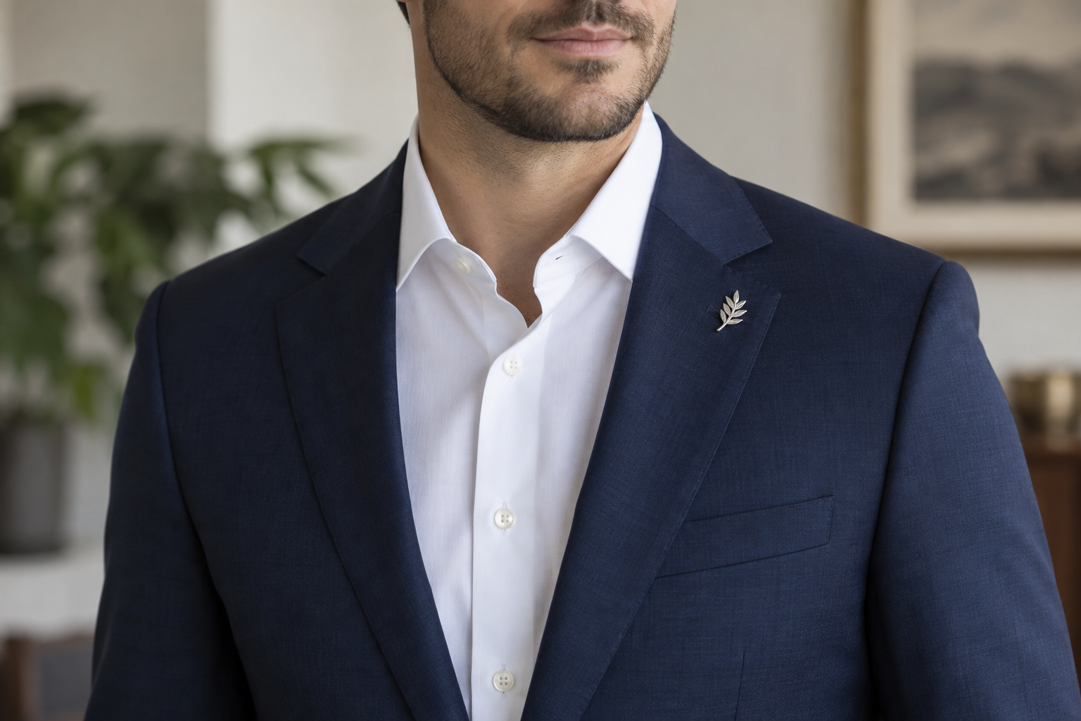 Small silver leaf brooch beside the wearer's left lapel buttonhole.