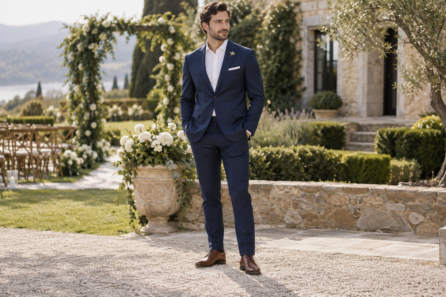Navy suit and white shirt with a small gold brooch at a garden wedding.