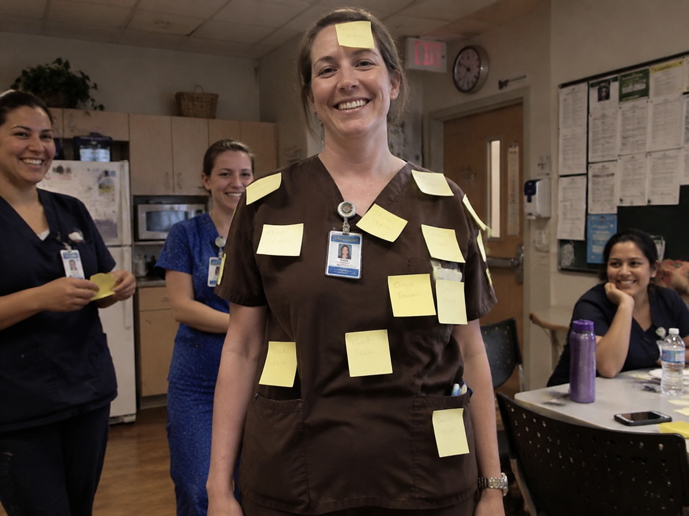 Nurse in brown scrubs covered in yellow sticky notes as a bulletin board costume