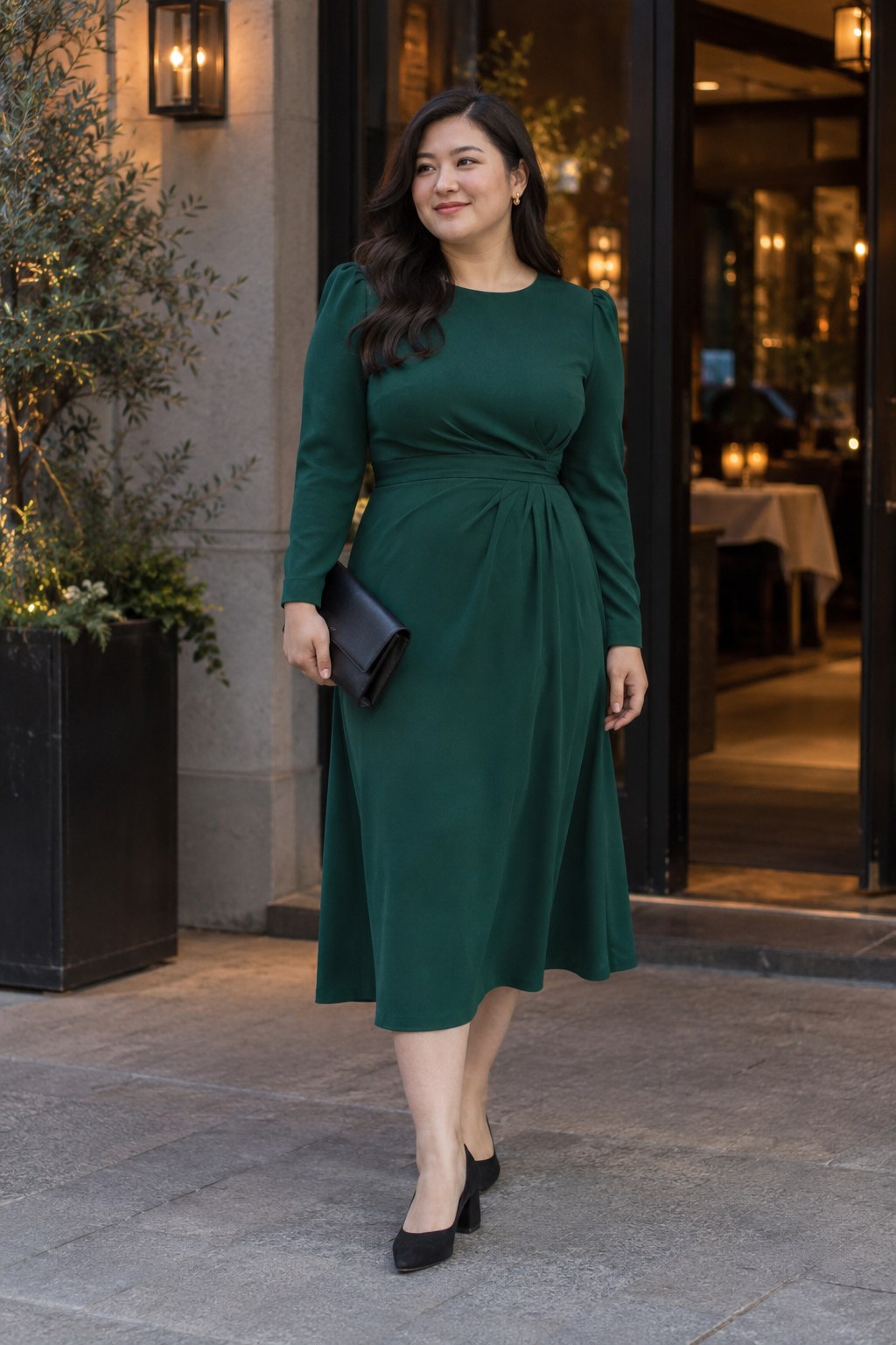 Emerald midi dress with sculpted shoulders, low black heels and a plain clutch.