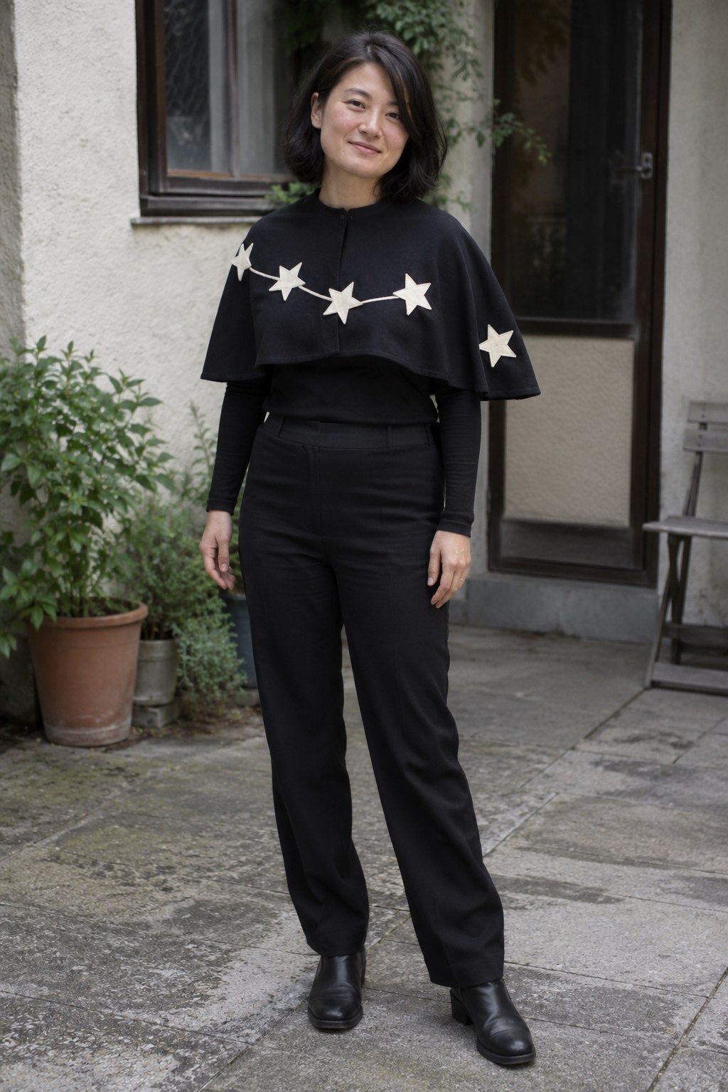 Black outfit with a short cape carrying an incomplete constellation in ivory ribbon