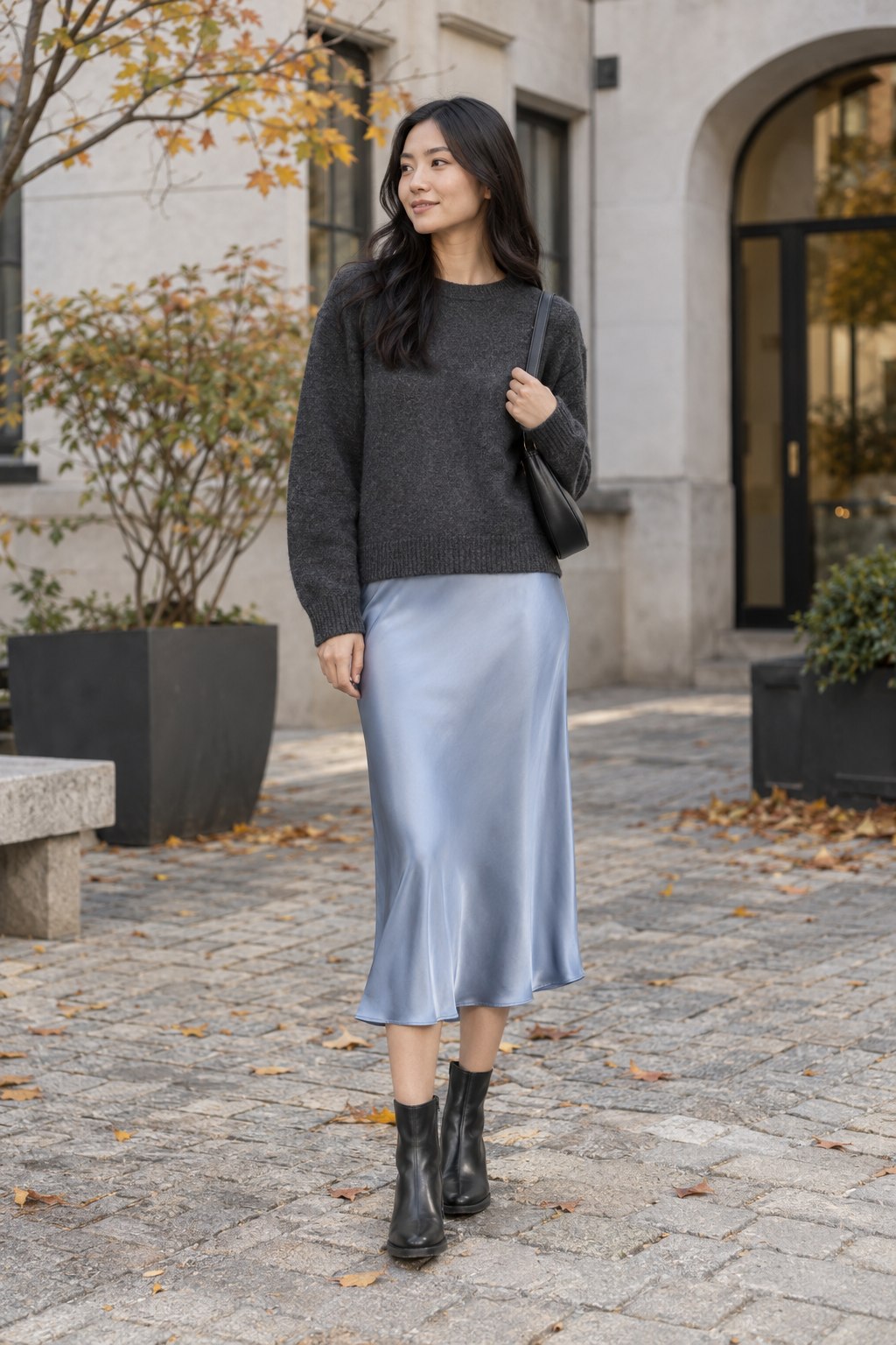 Icy blue satin midi skirt with a charcoal sweater and black ankle boots.