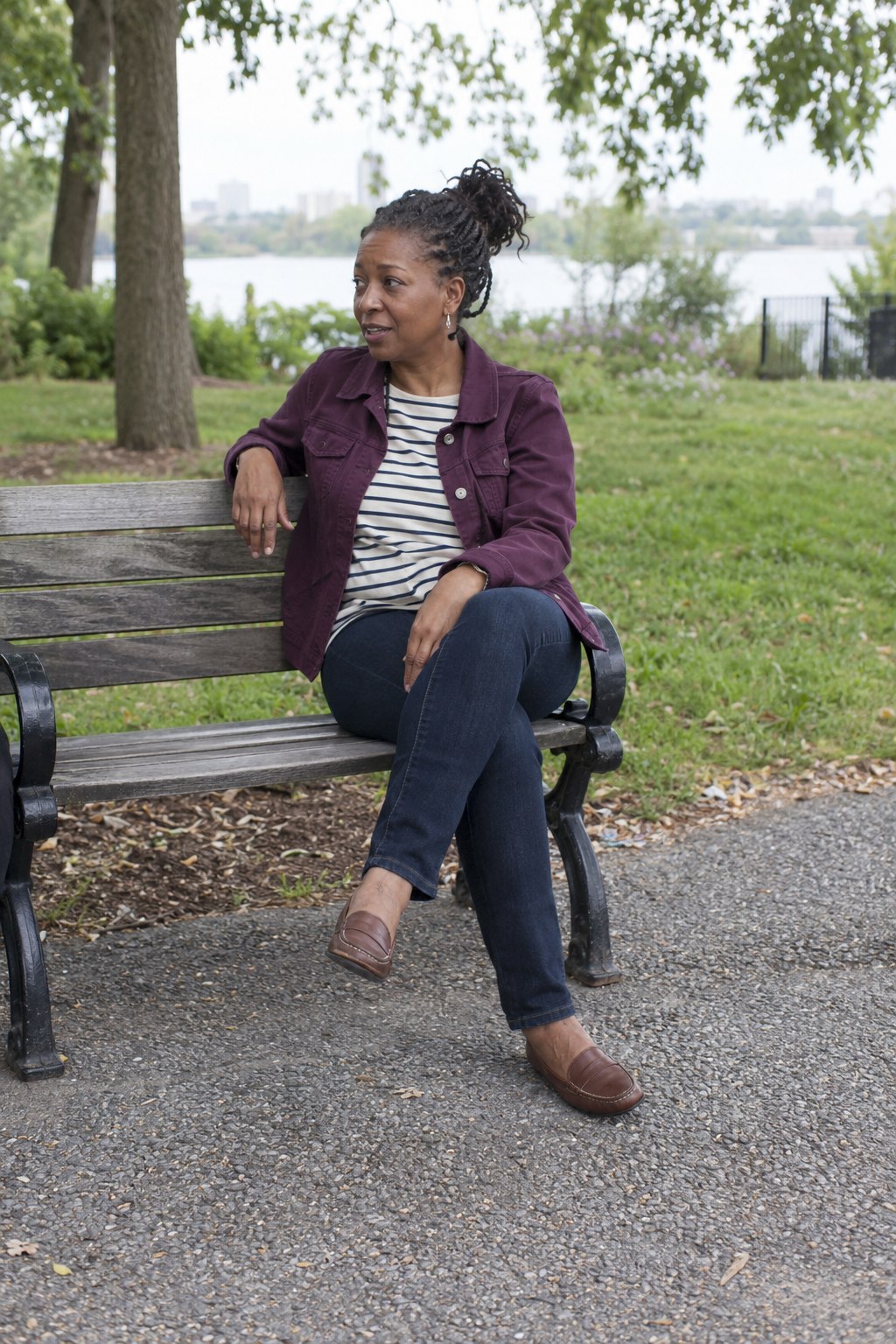 Plum jacket layered over a striped tee and dark jeans.
