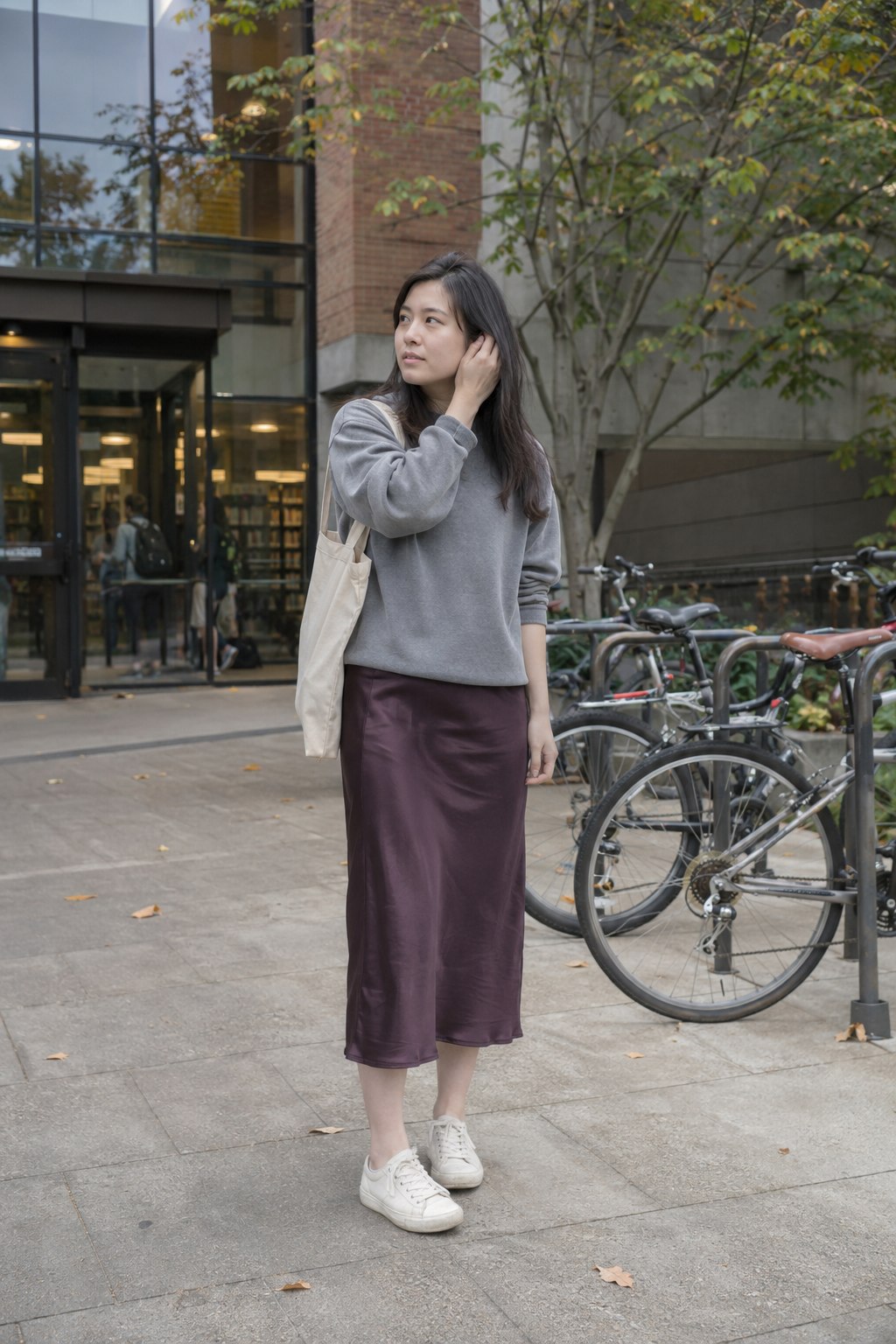 Plum satin midi skirt with a gray sweatshirt and off-white sneakers.
