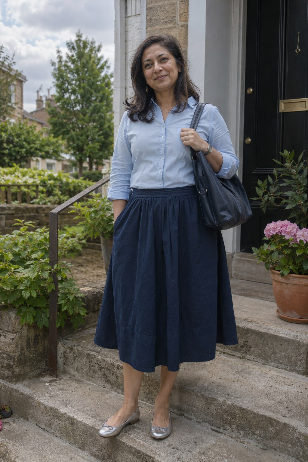 Silver flats with a navy midi skirt and pale blue shirt.