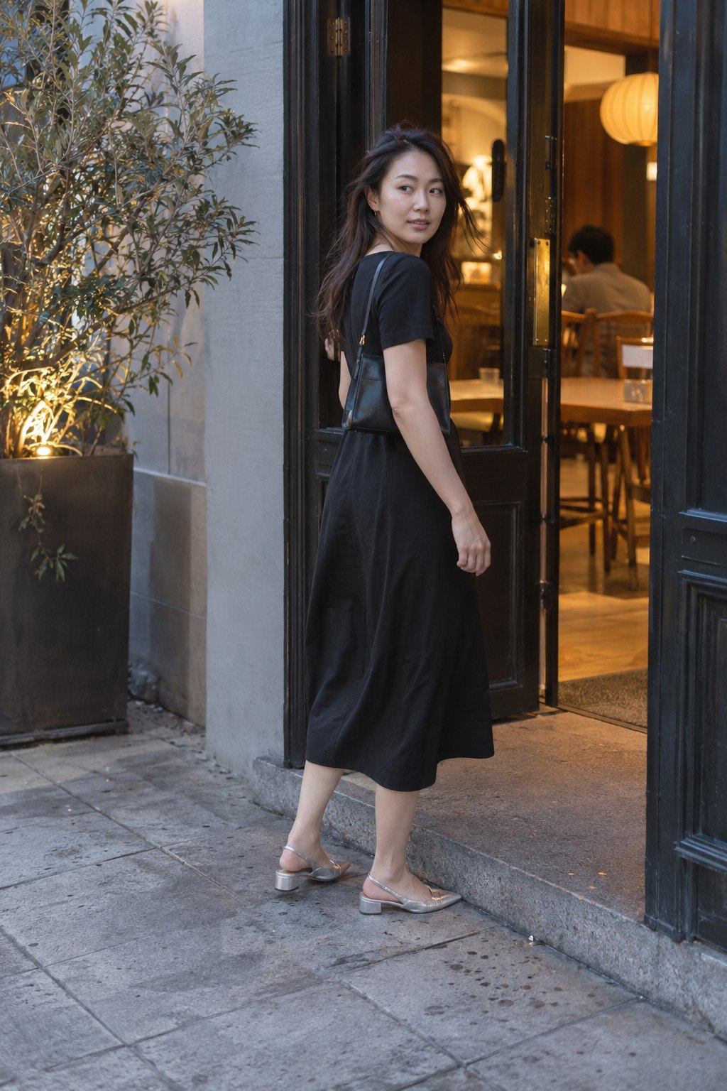 Silver slingbacks adding shine to a plain black midi dress.